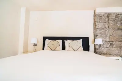 a bedroom with a large white bed with pillows at Urbi Apartments in Manresa