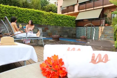 a group of people sitting on a deck near a pool at Montaltmar in Sant Vicenç de Montalt