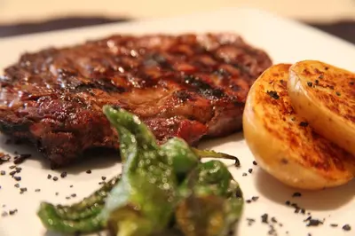 a steak with potatoes and broccoli on a white plate at Montaltmar in Sant Vicenç de Montalt