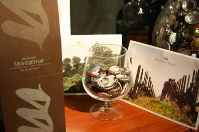 a wine glass filled with coins sitting next to a box at Montaltmar in Sant Vicenç de Montalt
