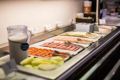 a buffet line with hot dogs and other foods at Holiday Inn Express Sant Cugat by IHG in Sant Cugat del Vallès