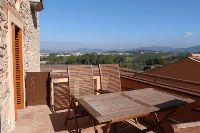 a wooden table and chairs on a balcony at Can Gramunt in La Torre de Claramunt