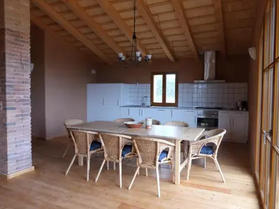 a dining room with a table and chairs in a kitchen at Can Gramunt in La Torre de Claramunt