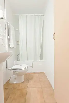 a white bathroom with a toilet and a shower at Hostal Ramos in Barcelona