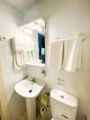 a bathroom with a sink and a toilet and a mirror at Hostal Ramos in Barcelona