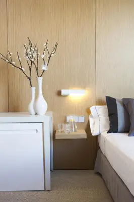 a bedroom with a bed and a vase with flowers on a table at Alenti Sitges Hotel in Sitges