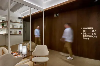 two men are walking in a room with a wall with aiger at The Moods Catedral Hostal Boutique in Barcelona