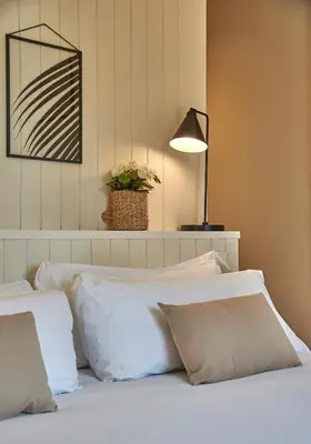 a bedroom with a bed with white pillows and a lamp at The Moods Catedral Hostal Boutique in Barcelona