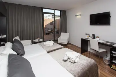 a hotel room with two beds and a desk with a computer at Catalonia Catedral in Barcelona