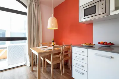a kitchen with a wooden table and a dining room at Inside Barcelona Apartments Sants in Barcelona