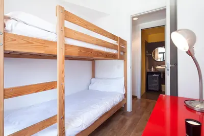 a bedroom with two bunk beds and a red table at Inside Barcelona Apartments Sants in Barcelona