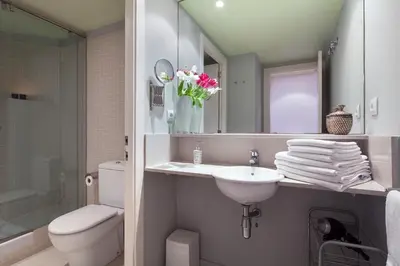 a bathroom with a sink and a toilet and a mirror at Inside Barcelona Apartments Esparteria in Barcelona