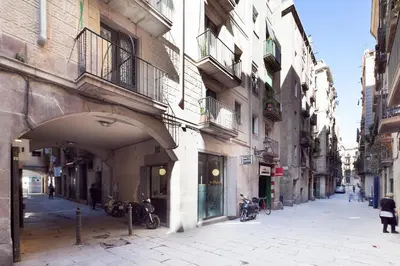 an alley in a city with buildings and motorcycles at Inside Barcelona Apartments Esparteria in Barcelona