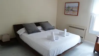 a bedroom with a large white bed with two pillows at Luxury Beach House in Sitges
