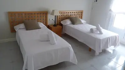 a bedroom with two beds with white sheets at Luxury Beach House in Sitges