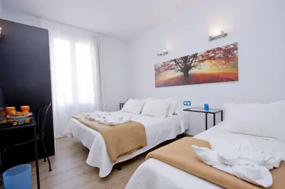 a room with two beds and a painting on the wall at Barcelona City Hotel in Barcelona