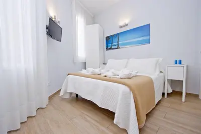 a white bedroom with a bed with white sheets at Barcelona City Hotel in Barcelona