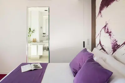 a bedroom with a bed with a book and a mirror at Allegro Barcelona in Barcelona