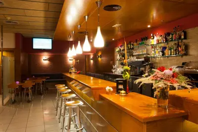 a bar in a restaurant with stools and a counter at Bed and Breakfast El Pekinaire in Calella