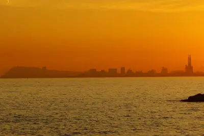 a sunset over the water with a city in the background at Vila De Premiá in Premiá de Mar