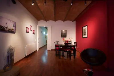 a dining room with a table and a red wall at Charm Rambla Catalunya in Barcelona