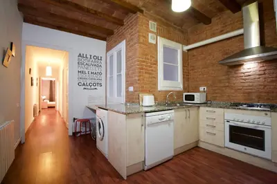 a kitchen with white appliances and a brick wall at Charm Rambla Catalunya in Barcelona