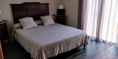 a bedroom with a bed with a wooden headboard and windows at Apartament Major 33 in Arbós