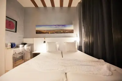 a bedroom with a large bed with white sheets and pillows at Hostemplo Sagrada Familia in Barcelona