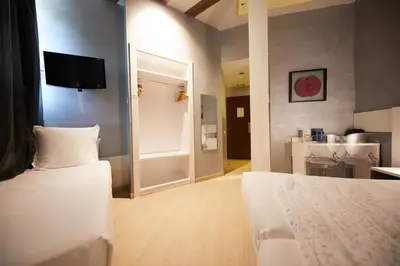 a room with two beds and a television on a wall at Hostemplo Sagrada Familia in Barcelona
