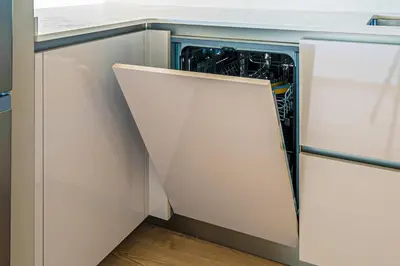 a dishwasher in a kitchen with white cabinets at Tango in Sitges