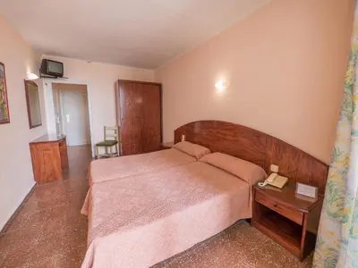 a bedroom with a large bed and a table at Checkin Garbí in Calella