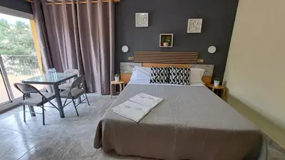 a bedroom with a bed and a table with chairs at Hotel Rodsan Suizo in Castelldefels