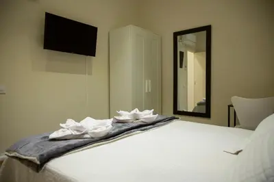 a bed with two white towels on it with a mirror at Barcelona City Ramblas in Barcelona