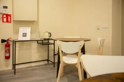 a table and chairs in a room with a fire extinguisher at Barcelona City Ramblas in Barcelona