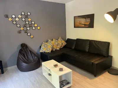a living room with a black leather couch and a table at Barcelona 54 Apartment Rentals in Barcelona