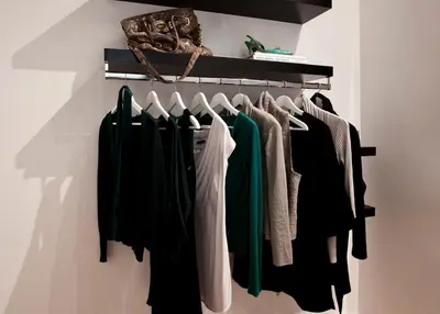 a closet with green and white clothes hanging on a rack at Centric Gracia Apartments in Barcelona