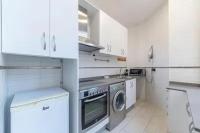 a small kitchen with a washing machine and a sink at Centric Gracia Apartments in Barcelona
