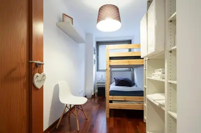 a small room with a bunk bed and a chair at Barcelona - Camp Nou in Hospitalet de Llobregat