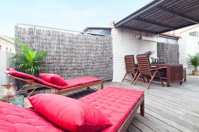 a patio with red pillows and a table and chairs at Apartment Barcelona Rentals - Penthouse with Terrace in Barcelona