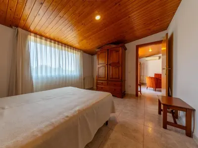 a bedroom with a large bed and a wooden ceiling at Apartamentos Sunway Tara in Sitges