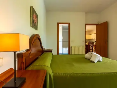 a bedroom with a green bed and a lamp at Apartamentos Sunway Tara in Sitges