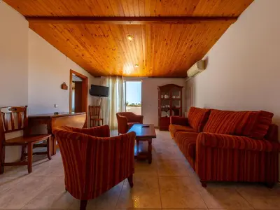 a living room with red furniture and a wooden ceiling at Apartamentos Sunway Tara in Sitges