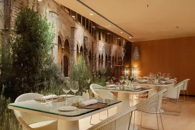 a restaurant with tables and chairs and a wall mural at Hotel Badalona Tower in Badalona