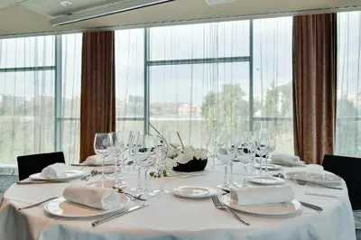a table with glasses and napkins on it in a room with windows at Hotel Badalona Tower in Badalona