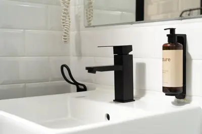 a bathroom sink with a bottle of wine on it at TSA La Mare in Barcelona