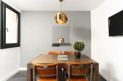 a dining room with a wooden table and chairs at TSA La Mare in Barcelona