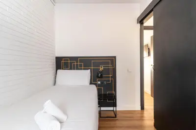 a bedroom with a white bed and a black headboard at TSA La Mare in Barcelona