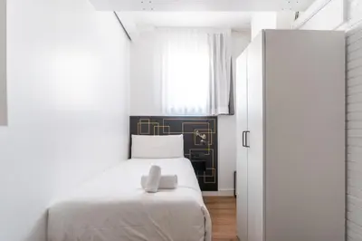a bedroom with a white bed and a window at TSA La Mare in Barcelona