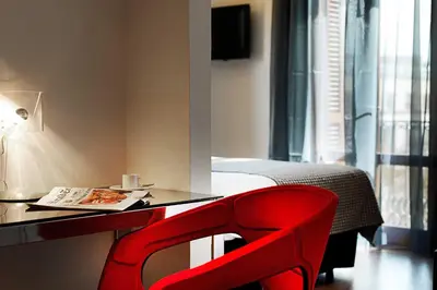 a red chair sitting in front of a desk at Dorma Ramblas Boquería in Barcelona