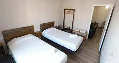 a hotel room with two beds and a mirror at L'Hostalet d'Arenys de Mar in Arenys de Mar